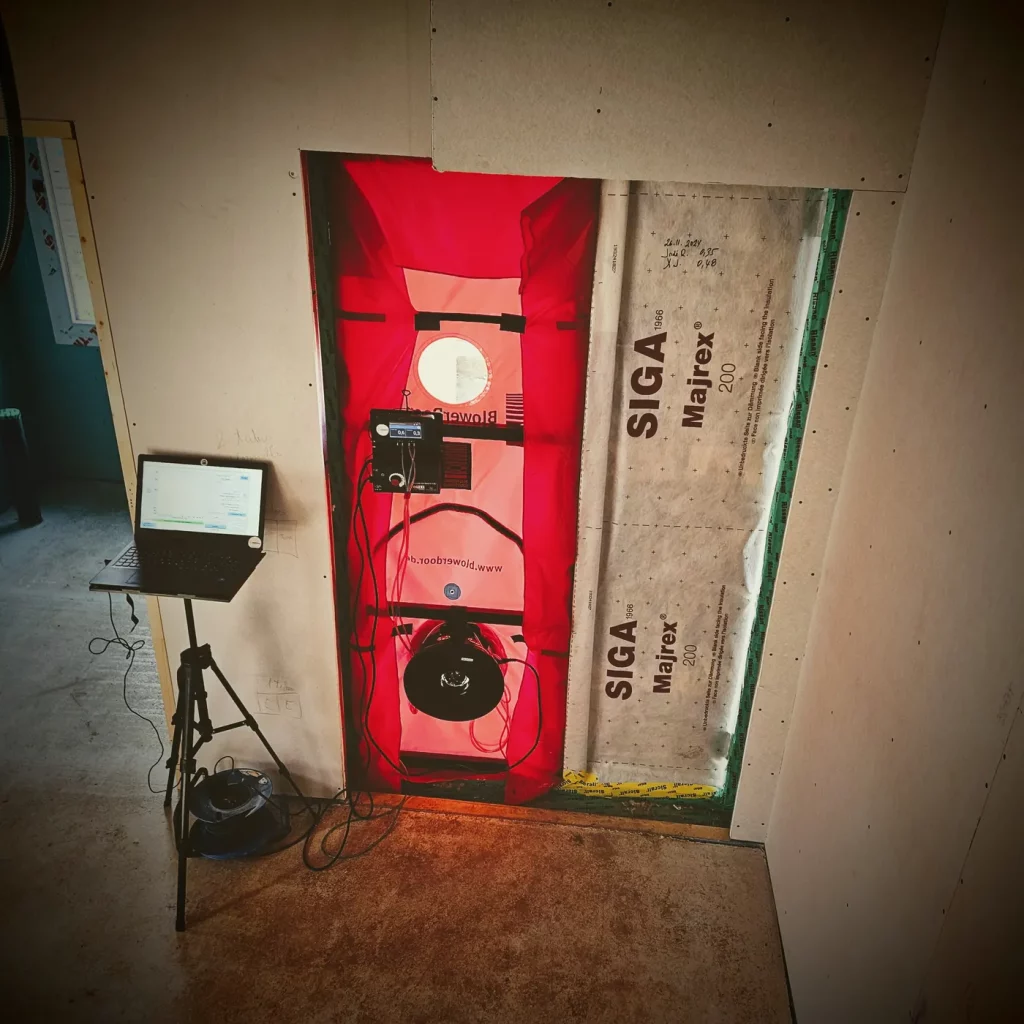 Ensayo de hermeticidad al aire (Blower Door) instalado en la puerta de una vivienda, con membrana SIGA Majrex en la envolvente; método conforme a UNE-EN ISO 9972:2019.
