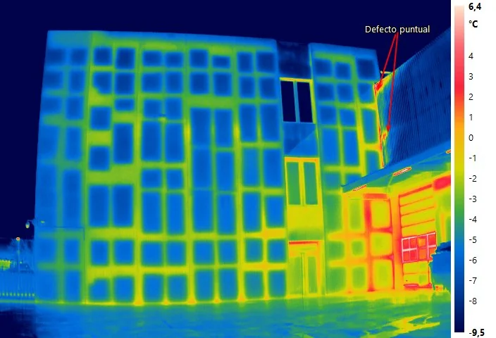 Termograma de la envolvente de un edificio terciario con marcador de defecto puntual en fachada; evidencia que produce el método C.A.L.O.R. de inspección termográfica, según UNE-EN ISO 6781-1:2023.